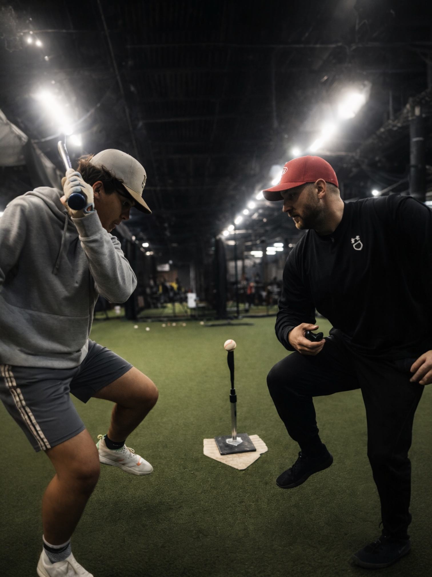 Coach Steve working with Sam in the cage, watching his swing from behind the plate